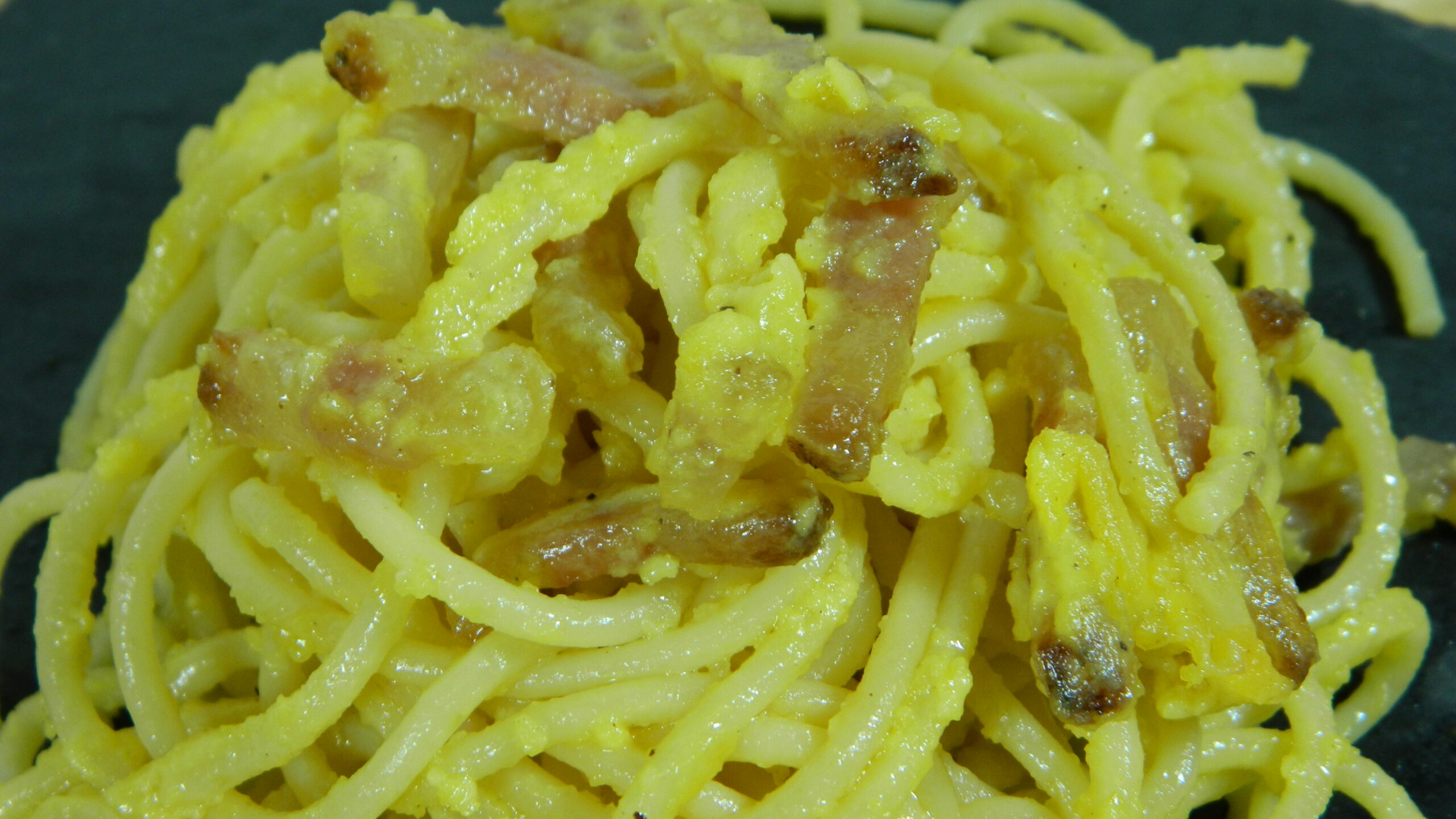 Spaghetti alla carbonara con uova, formaggio pecorino romano DOP, guanciale, pepe. Primo piatto di pasta tradizionale della cucina italiana.